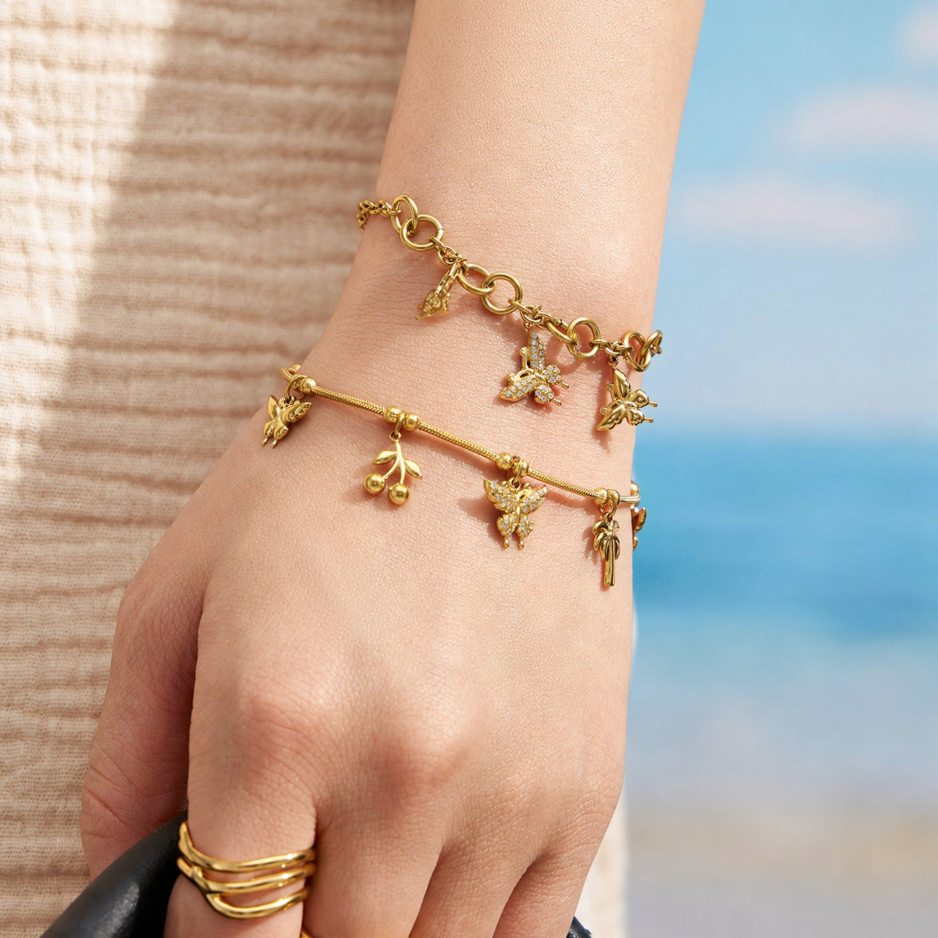 Gold multi-charm butterfly bracelet styled on a model wrist