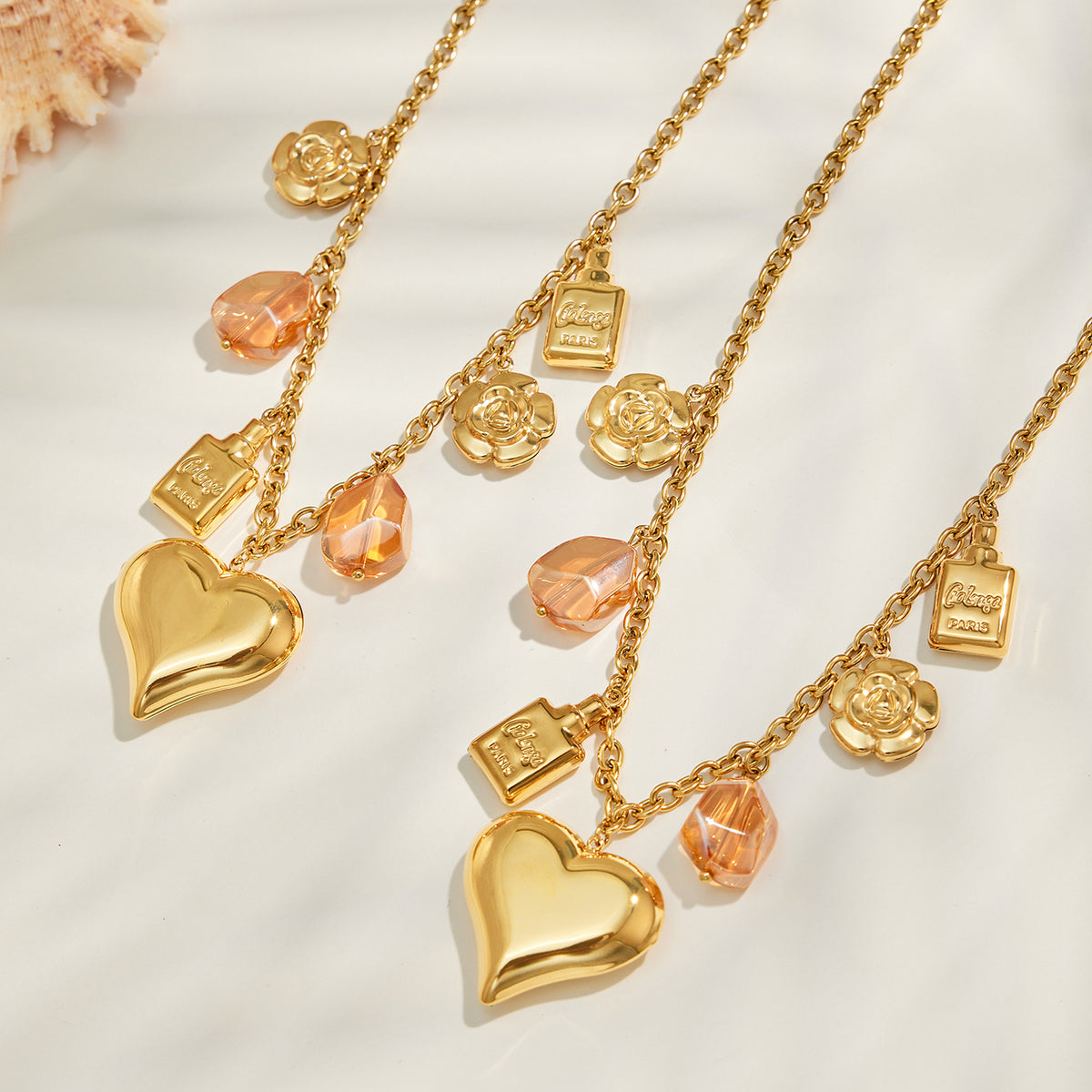Gold multi-charm necklace with heart, flower and resin pendant details