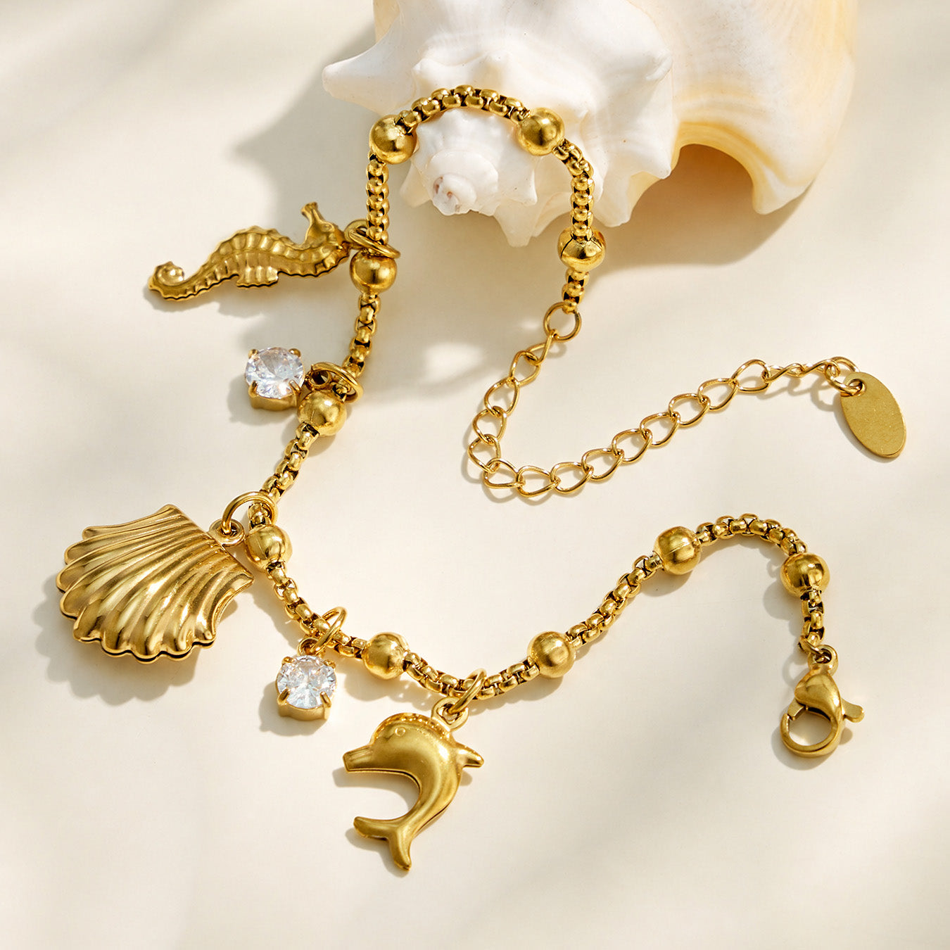 Full view of a gold ocean-inspired charm bracelet with an adjustable extender chain