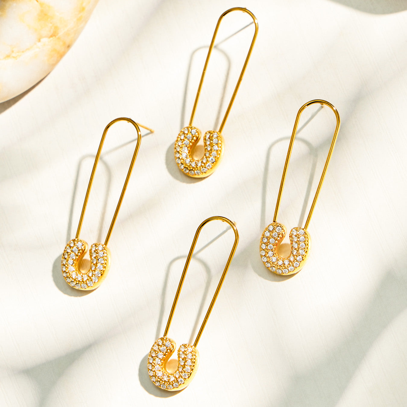 Gold paperclip-inspired drop earrings with clear cubic zirconia accents