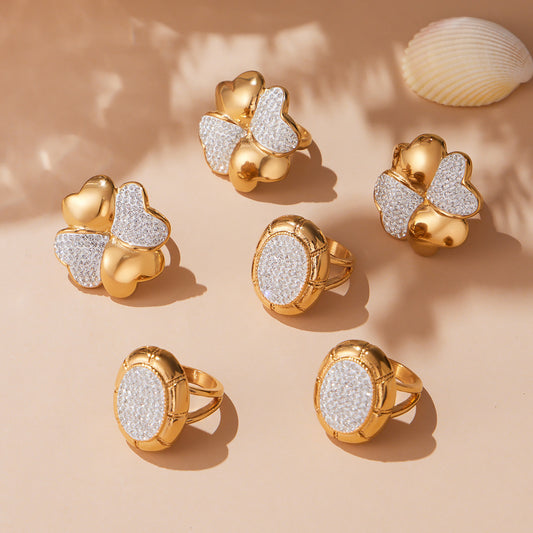Gold pavé statement rings in round and clover styles arranged together on a neutral display