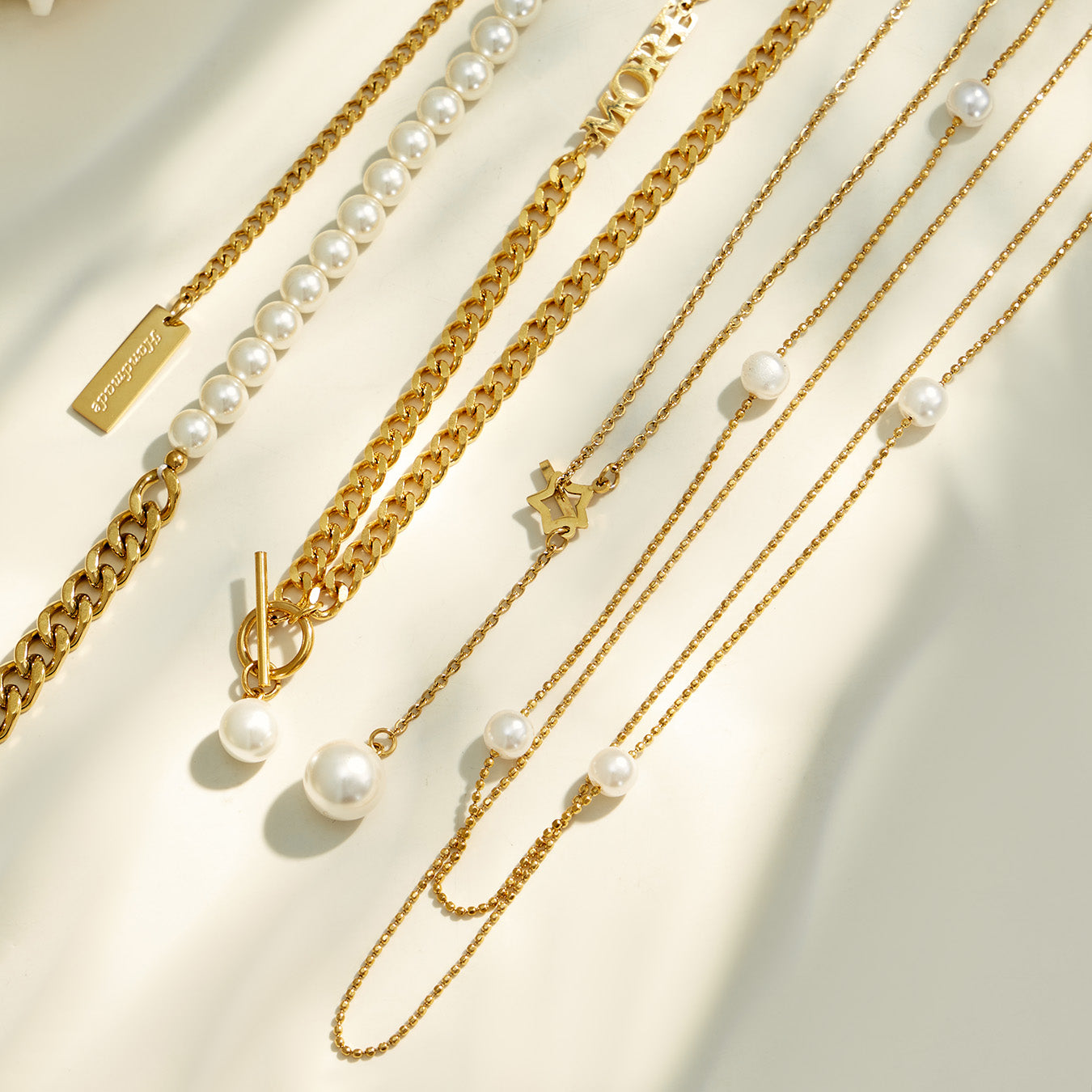 Gold faux pearl and layered necklaces displayed together in a wholesale style assortment