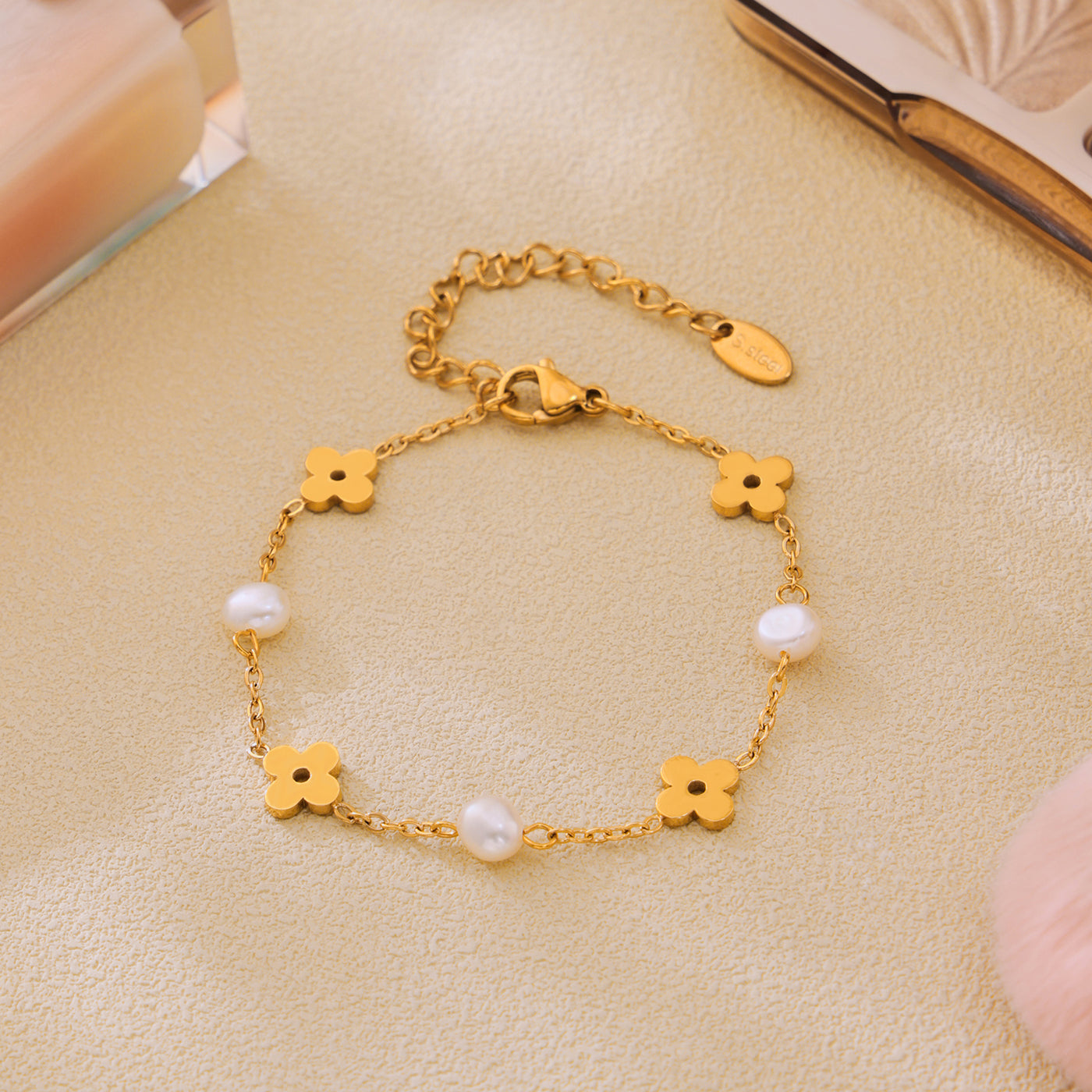 Freshwater pearl clover bracelet displayed flat with polished gold-tone floral details