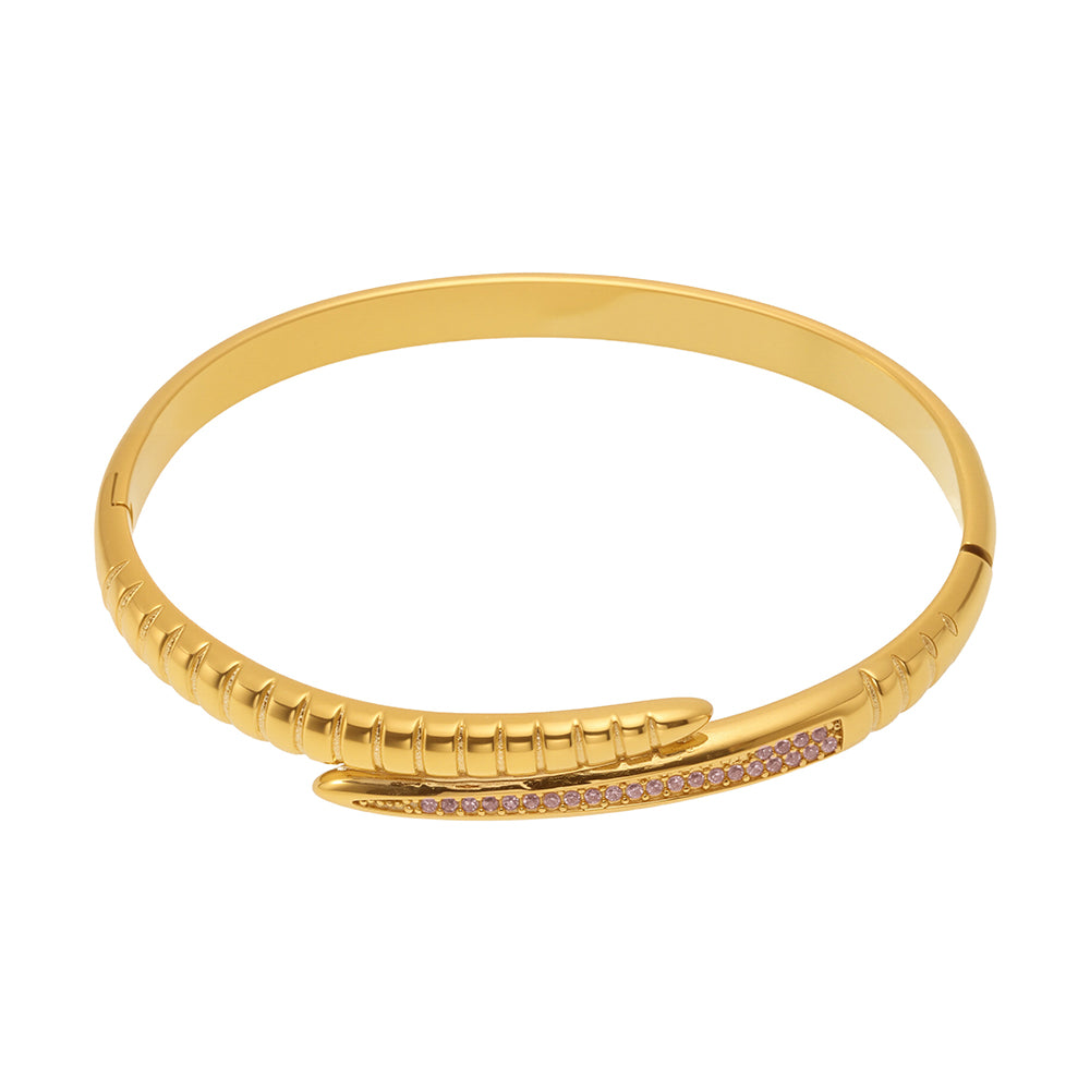 Gold-tone nail bangle bracelet with pink zircon accents on a white background
