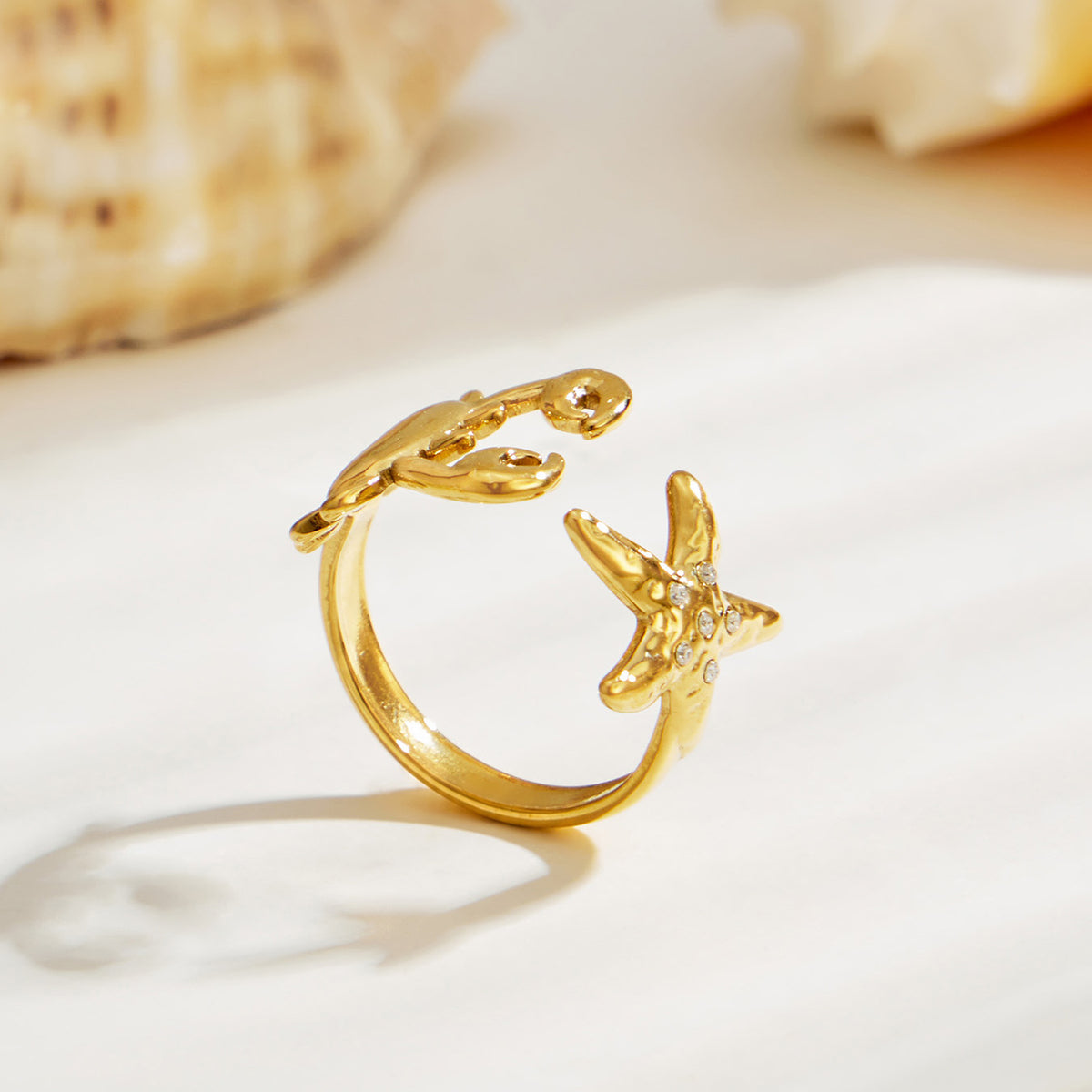 Gold ocean-inspired open ring featuring sculptural starfish and crab motifs in 316L stainless steel