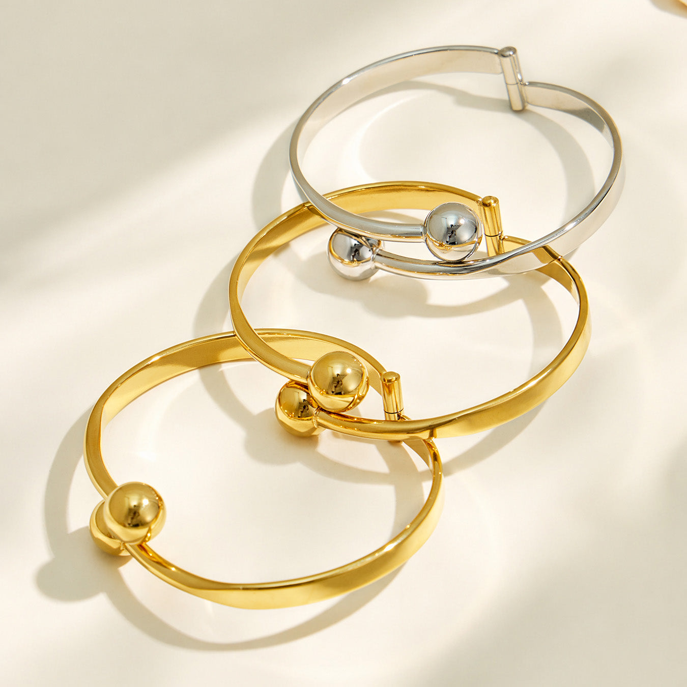 Gold and polished steel double ball cuff bracelet finish options displayed together