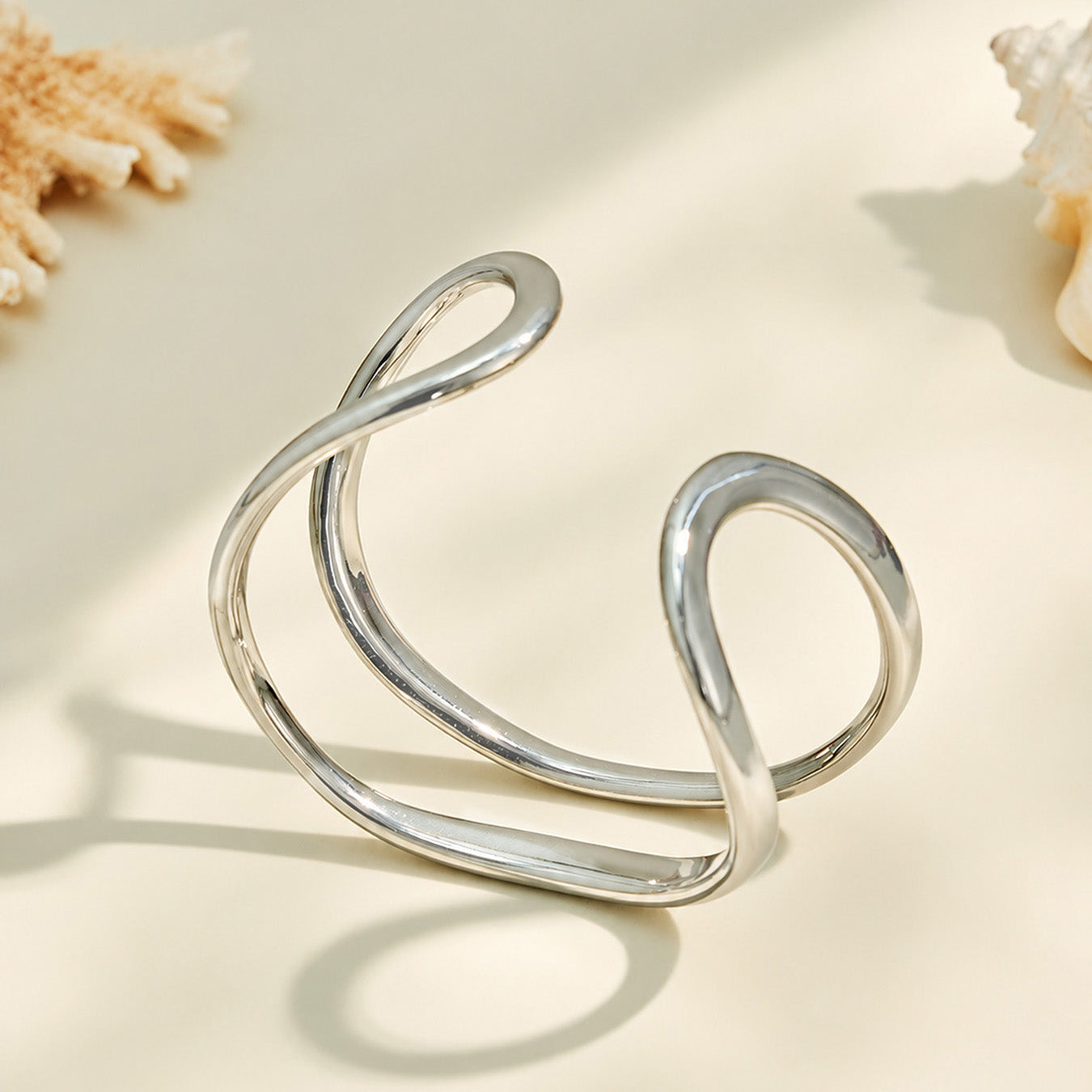 Gold and polished steel double loop cuff bracelets displayed together