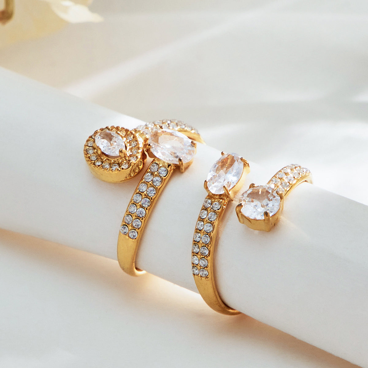 Gold-tone and steel-tone stainless steel CZ open rings displayed together for wholesale selection