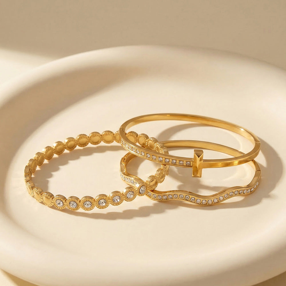 Gold zircon bangle bracelet set with H buckle cuff, wavy zircon bangle and round zircon bracelet on elegant gift display