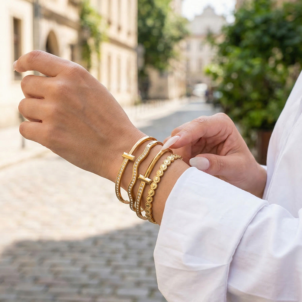 Model wearing gold zircon bangle bracelet stack with H buckle cuff, wavy zircon bangle and round zircon bracelet for boutique styling