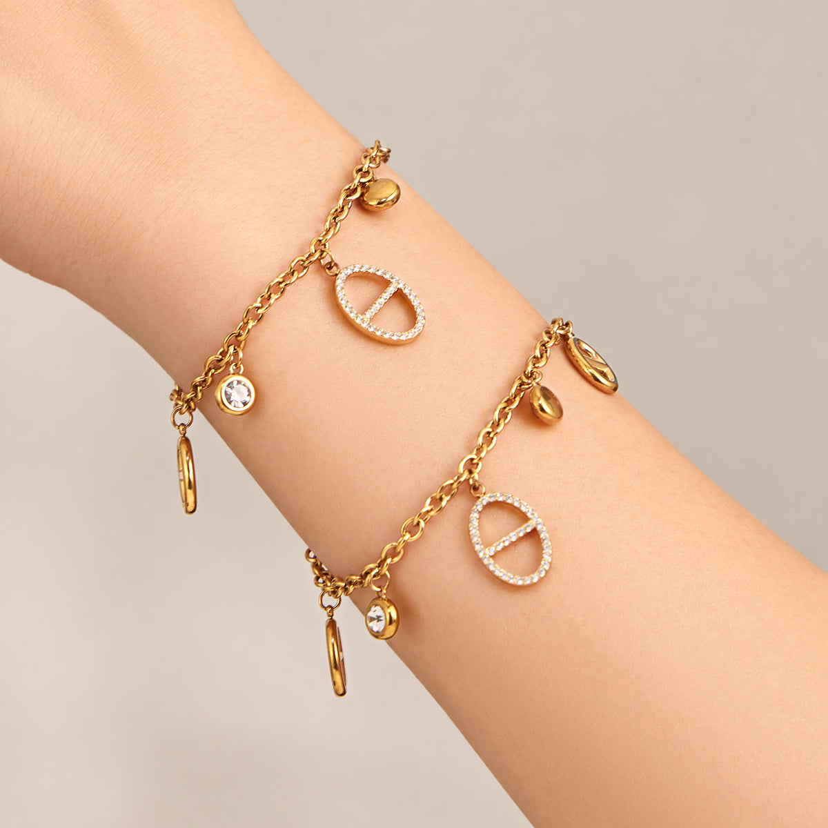 Gold zircon charm bracelet with geometric details worn on wrist