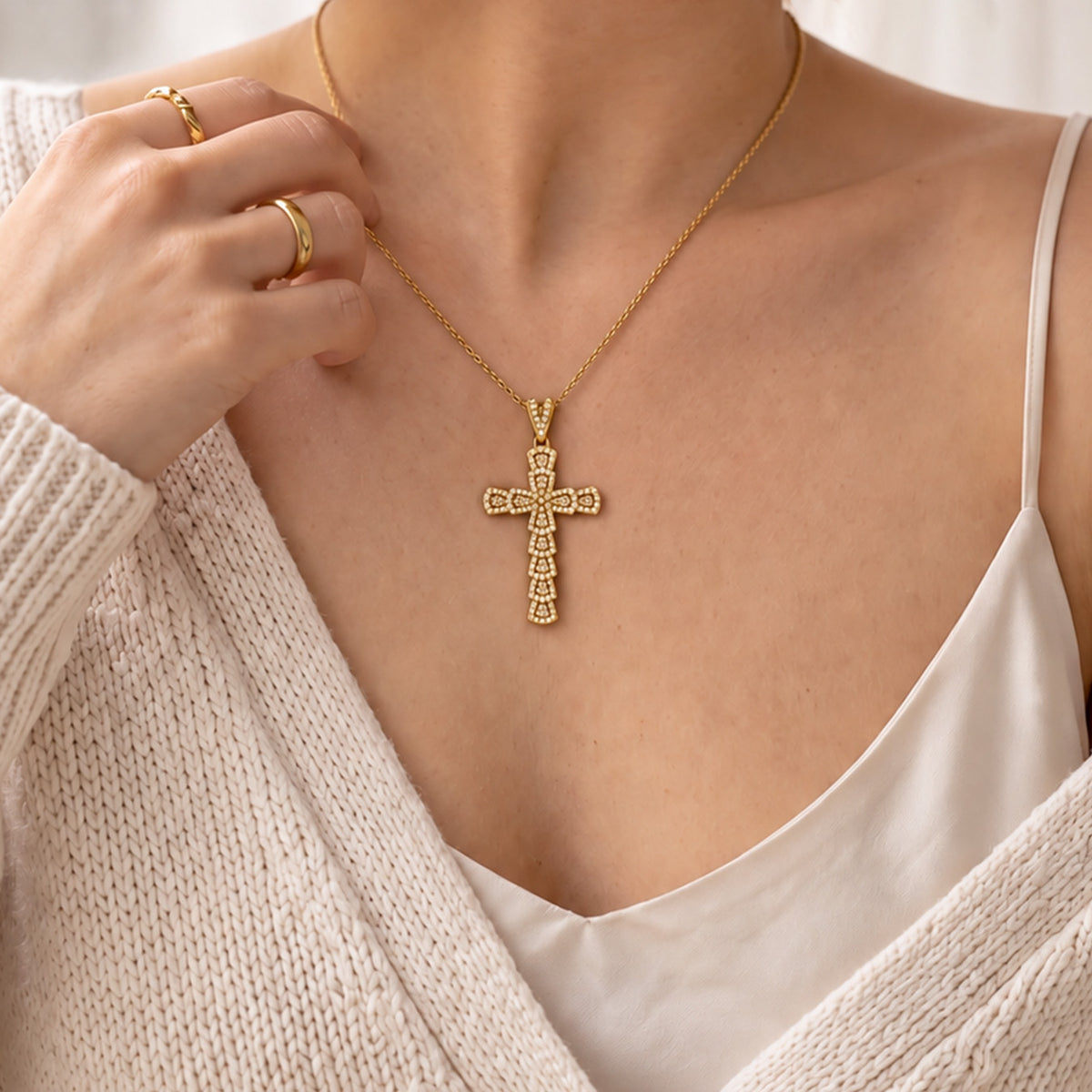 Gold zircon cross necklace worn on model