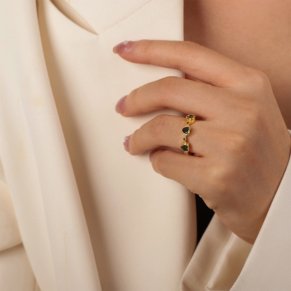 Side view of a model wearing a delicate green heart zircon ring