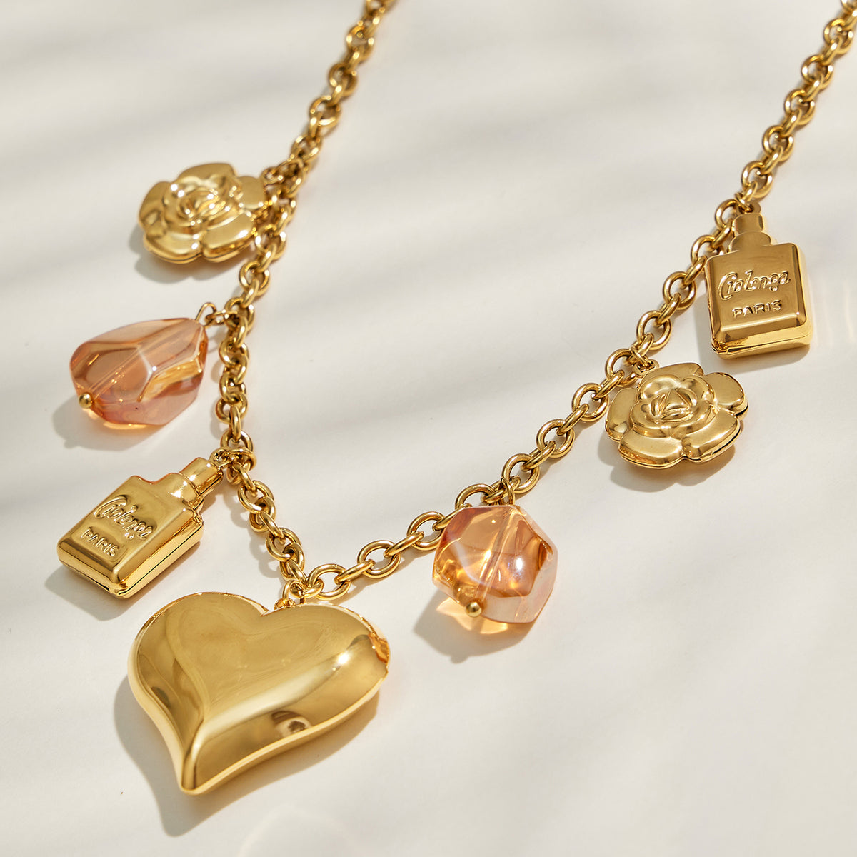 Gold heart charm necklace with translucent resin and floral charm details