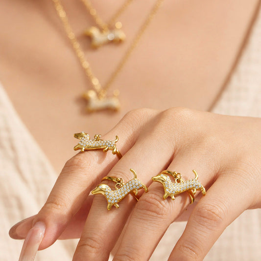 Dachshund zircon pendant necklace and matching decorative ring arranged on ivory fabric