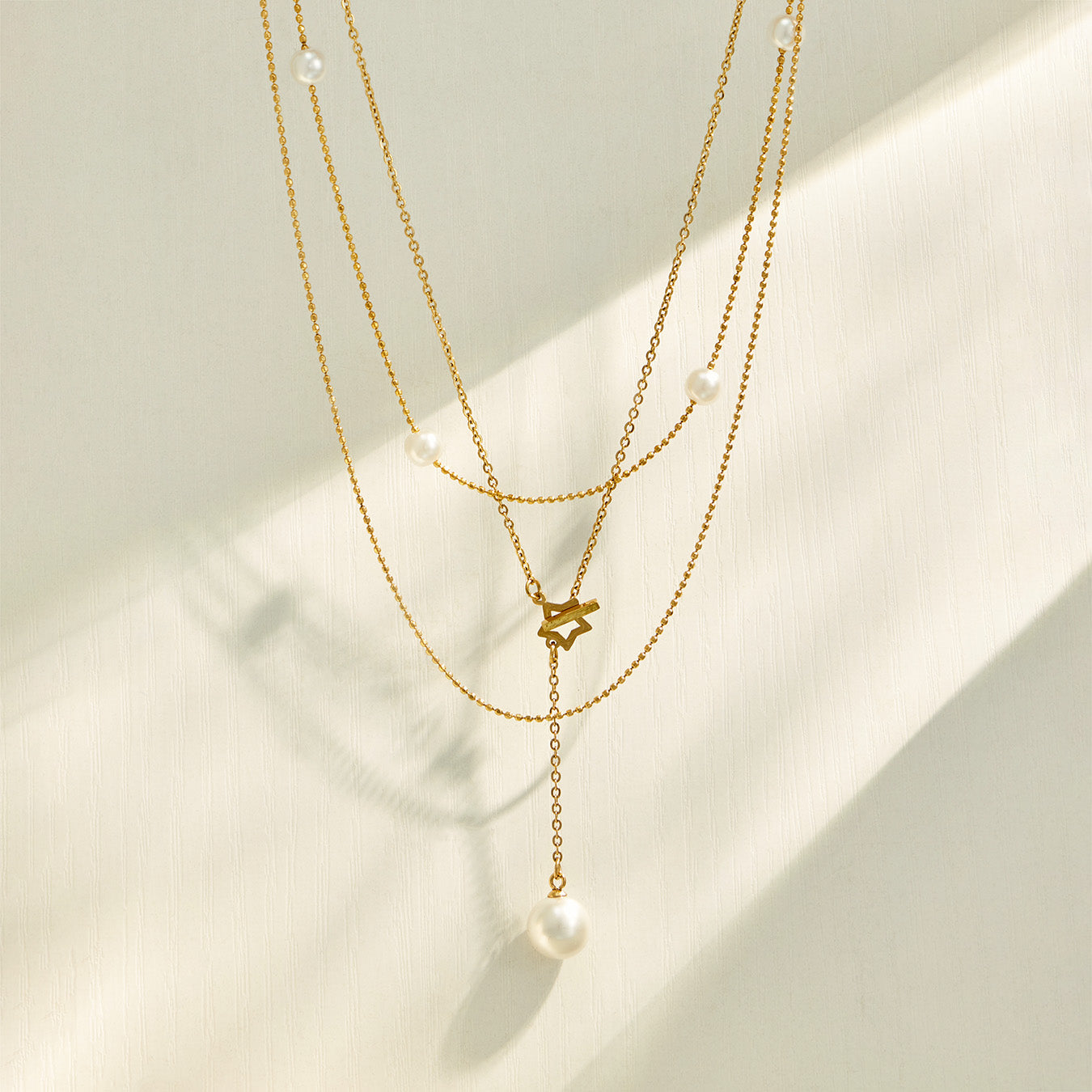 Layered gold necklace assortment with faux pearl, geometric and Y-shaped designs