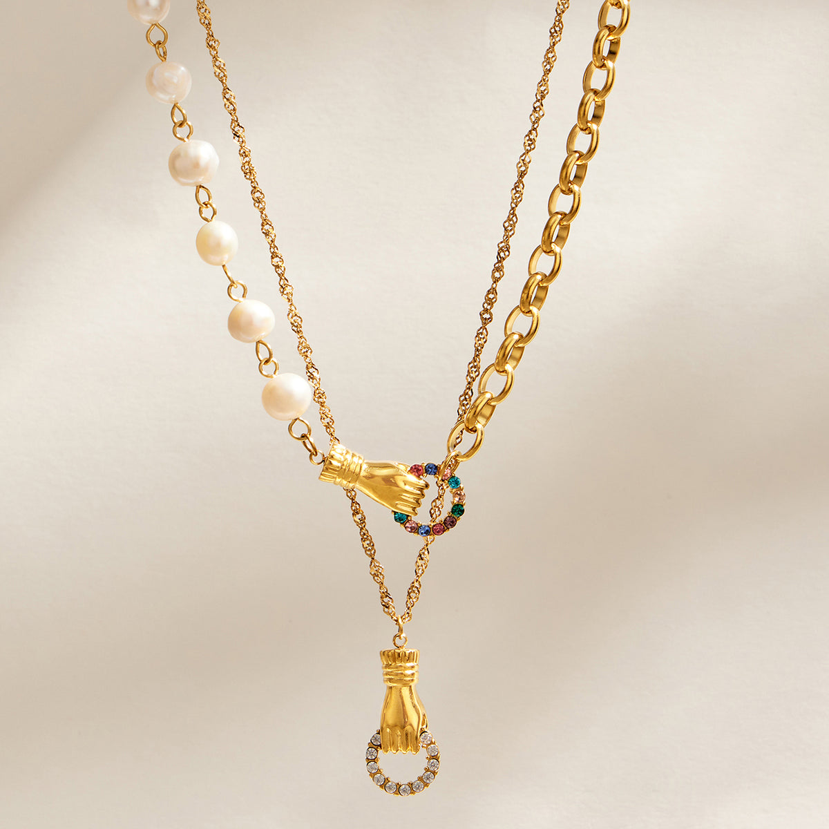 Layered freshwater pearl and gold chain necklaces with zircon connector and pendant details
