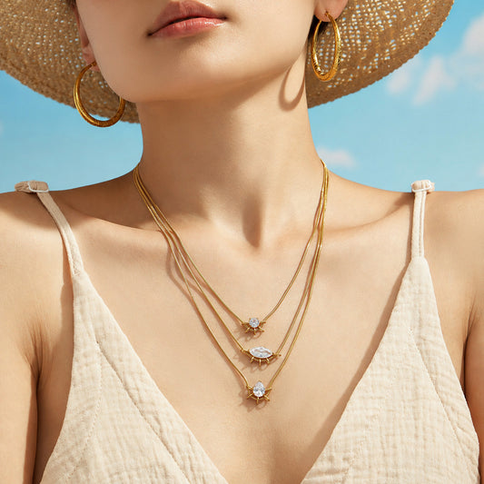 Model in a straw hat wearing layered geometric zircon pendant necklaces