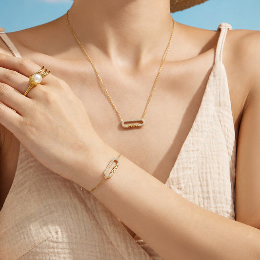 Model styling a gold MAMA zircon necklace with the matching letter bracelet