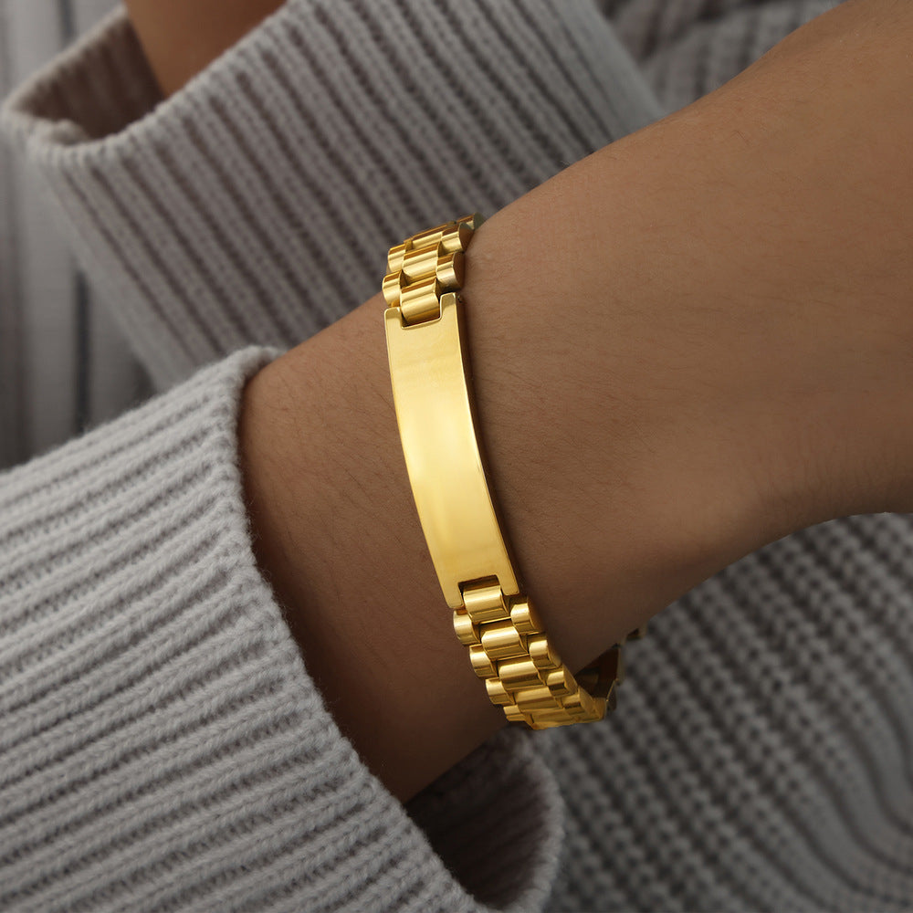 Men’s gold ID link bracelet worn on wrist with polished center plate and structured stainless steel links for boutique buyers