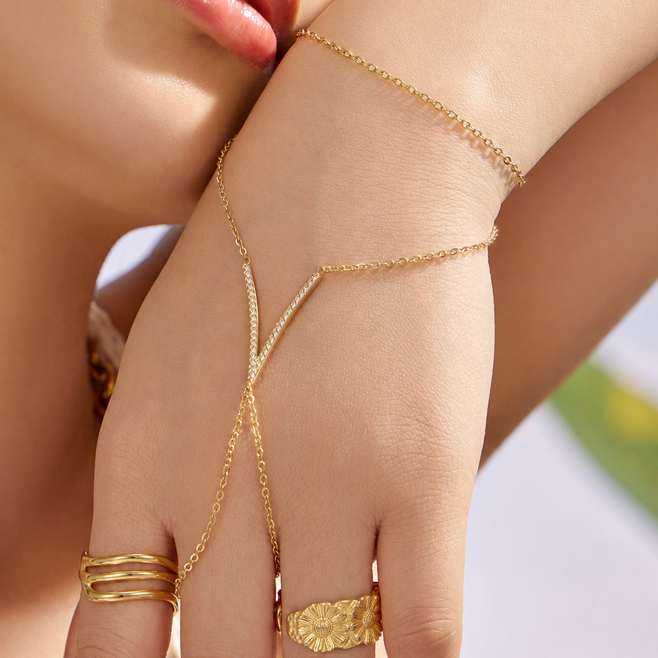 Model wearing gold zircon hand chain bracelet with V-shaped charm, 316L stainless steel finger bracelet for boutique jewelry styling