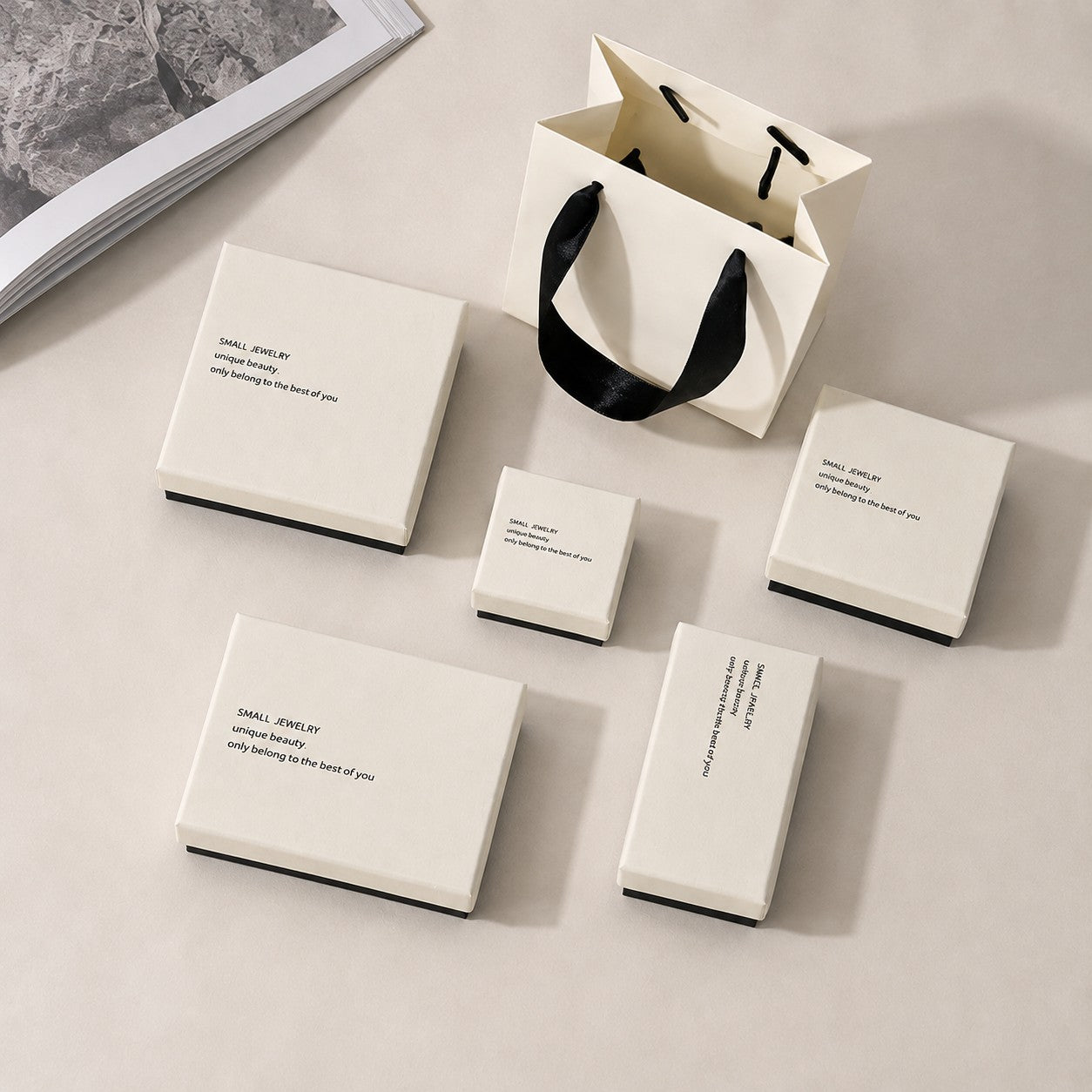 Minimalist white and black jewelry boxes arranged for boutique retail packaging display