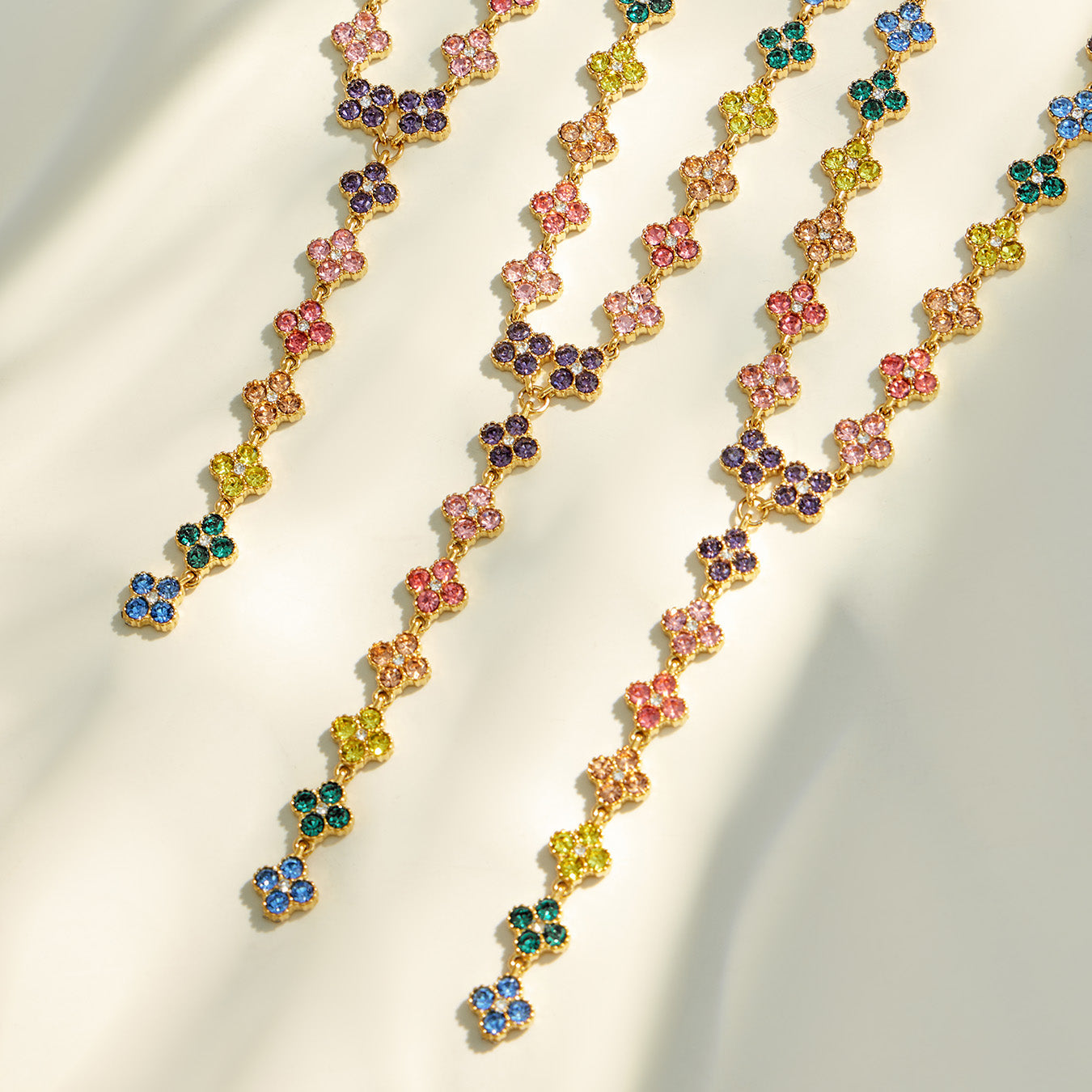 Close-up of multicolor four-petal zircon flower links in a gold-tone setting