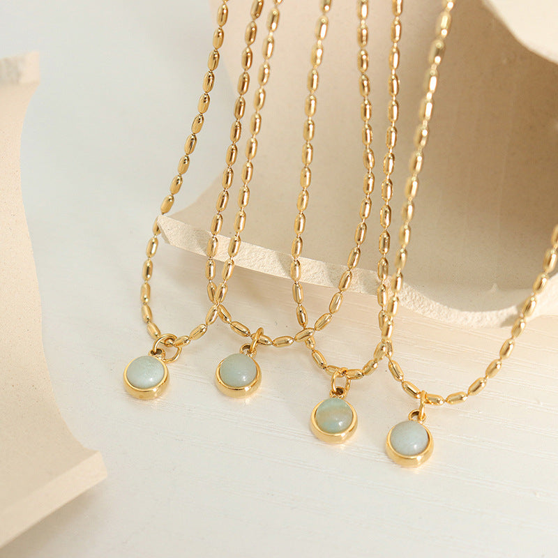 Multiple natural stone pendant necklaces with gold stainless steel chains displayed together for boutique presentation