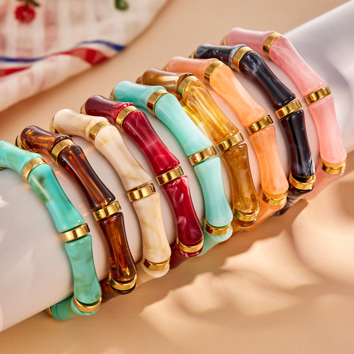 Colorful resin bamboo bangles displayed in a row on a bracelet stand.