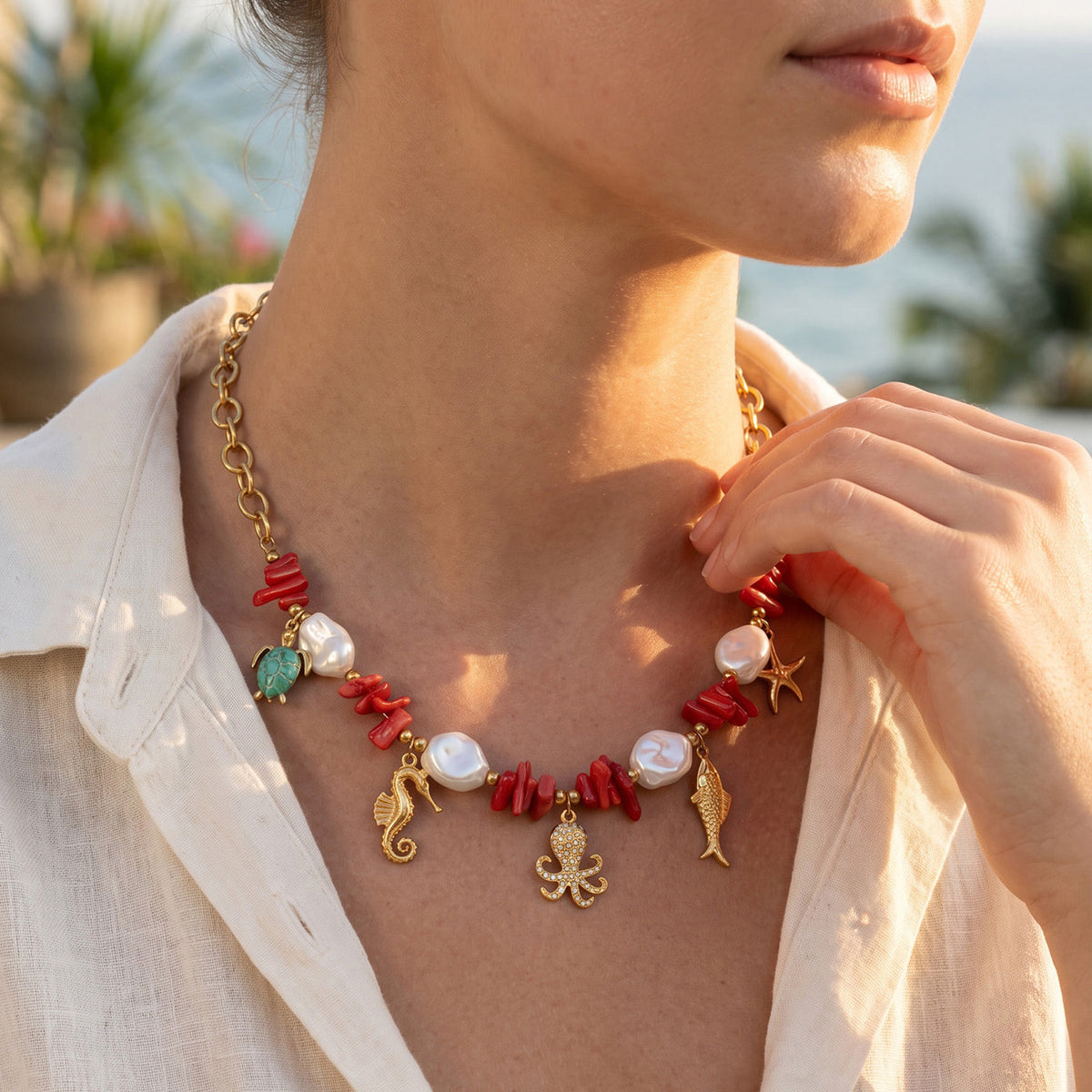 Ocean animal charm necklace with red coral-style beads and gold sea life motifs