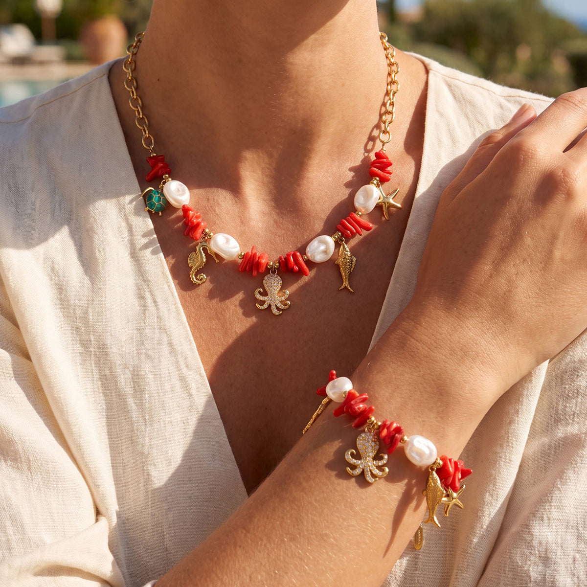 Matching ocean animal charm necklace and bracelet styled together on model
