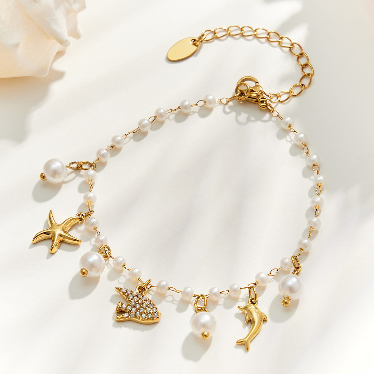 Gold manta ray ocean charm pearl bracelet with starfish, dolphin and pearl bead details