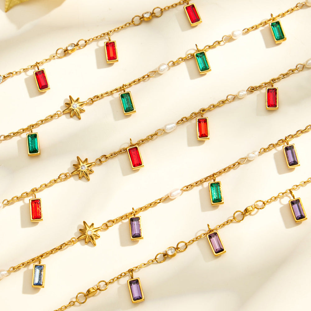 Close up of gold tone glass stone charm necklace with colorful pendant and delicate chain details