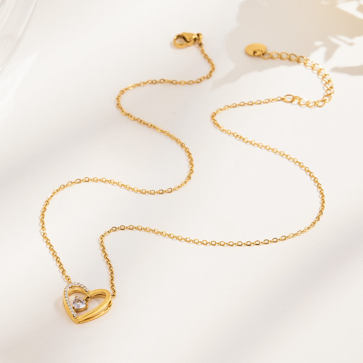 P556 gold-tone zircon heart pendant necklace shown in full-length flat lay
