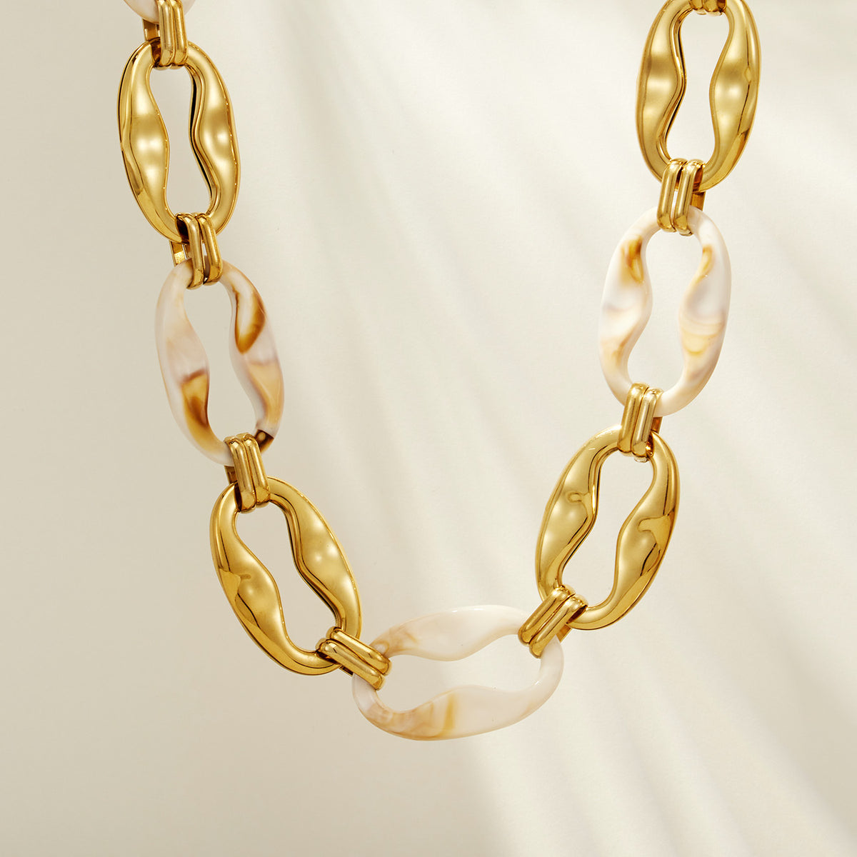 Close-up of P680 geometric resin chain necklace with ivory resin links and oversized gold stainless steel links