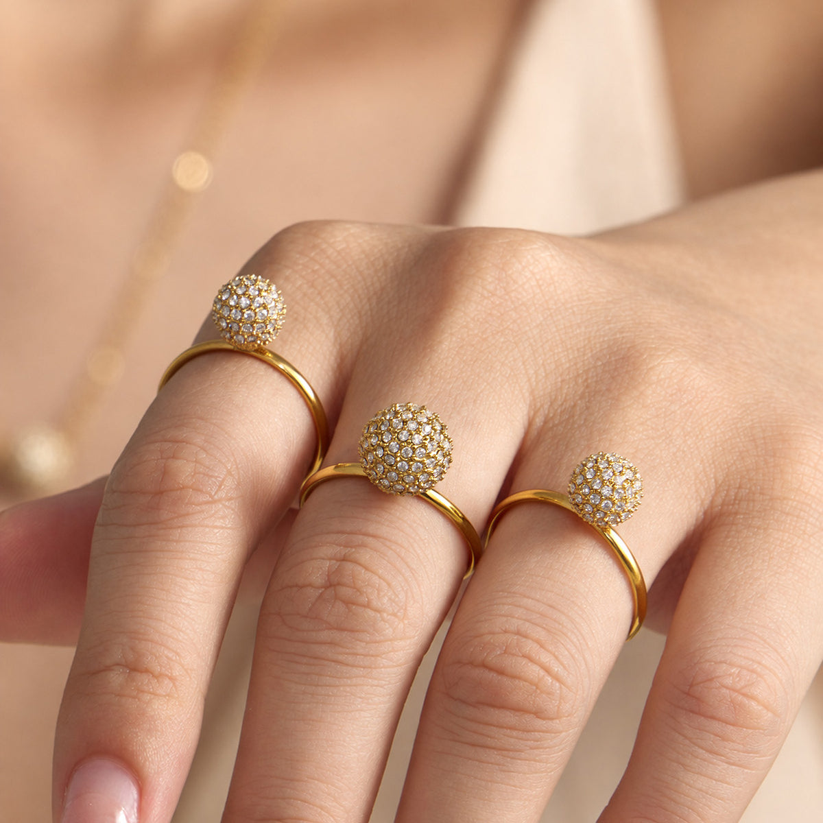 Gold pavé zircon ball open rings styled together on model hand