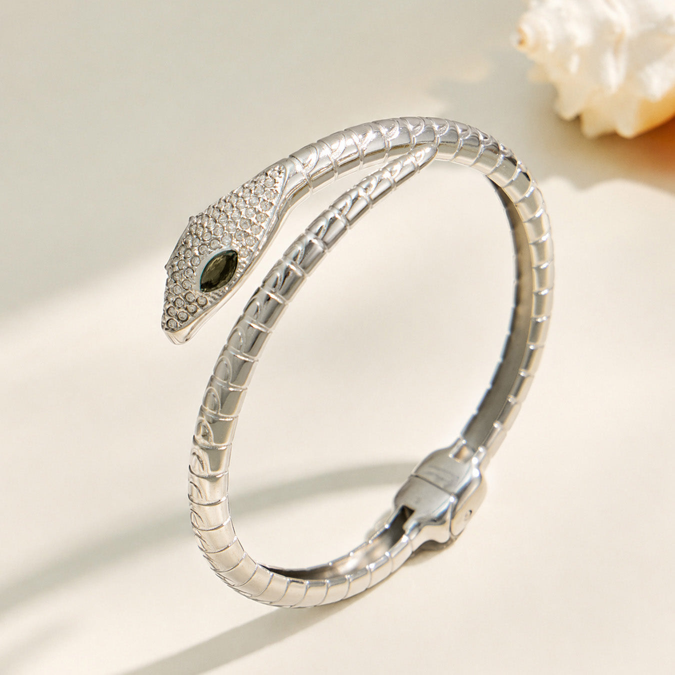 Polished steel snake open bangle with green zircon eyes and clear pavé details
