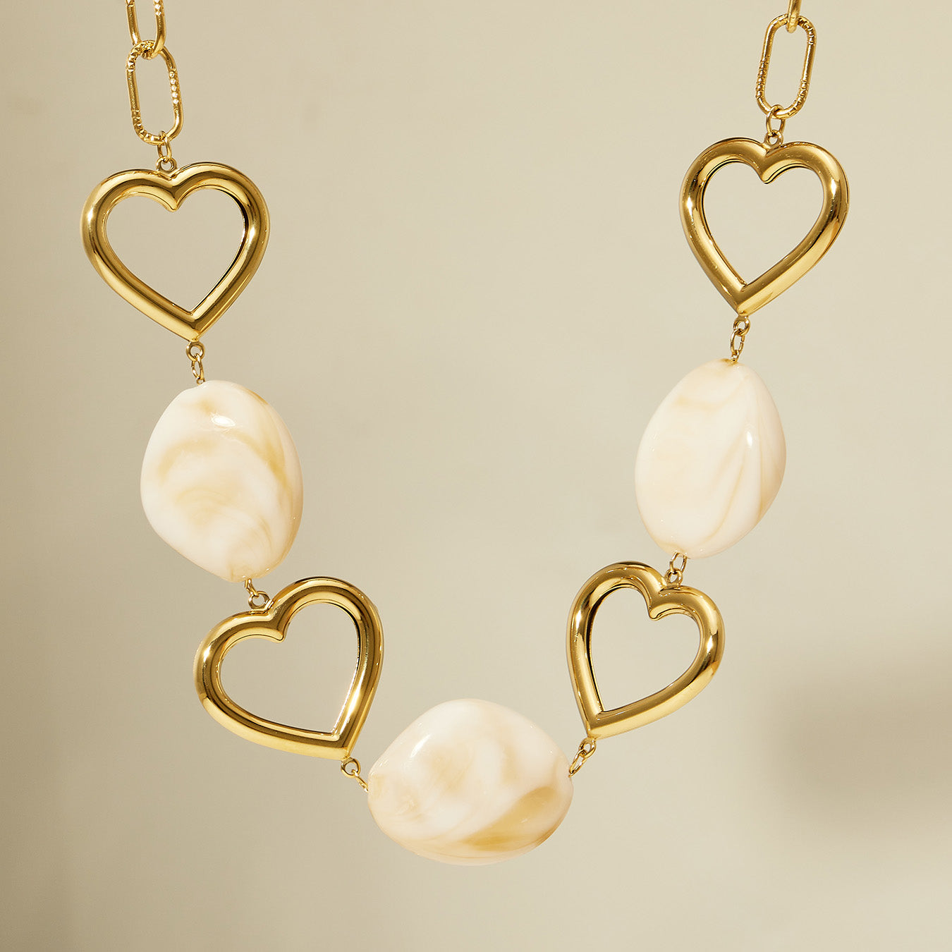 Resin heart necklace with gold-tone 316L stainless steel links and ivory resin pieces
