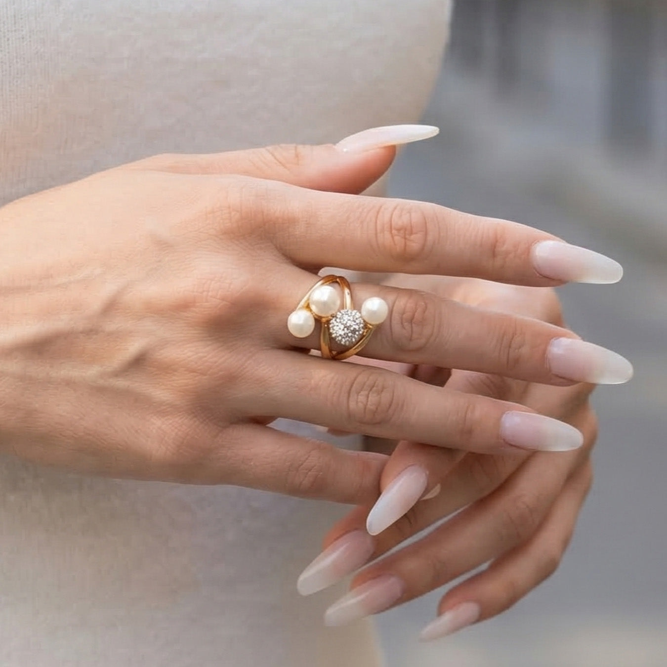Side view of sculptural faux pearl rings styled across a model hand