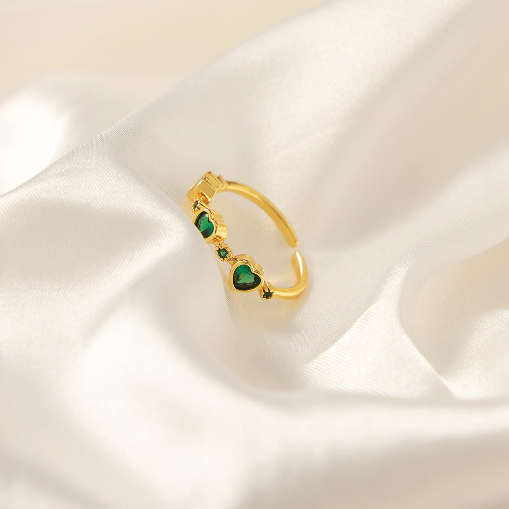 Single green heart zircon ring displayed upright on soft ivory satin