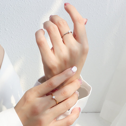 Silver tone minimalist solitaire stacking ring worn on hand for everyday boutique jewelry styling