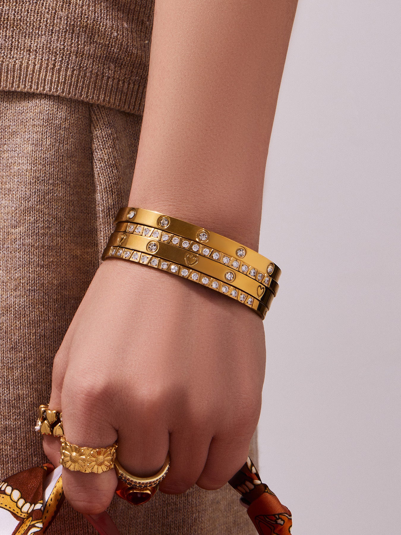 Close-up of a slim gold bangle bracelet worn on the wrist