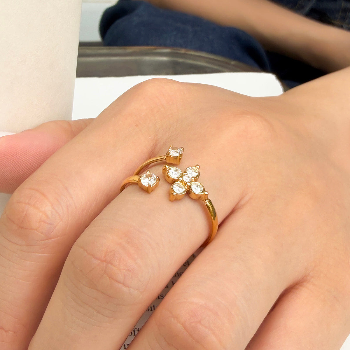 A471 gold-tone stainless steel flower open ring worn on a finger, showing round clear stones