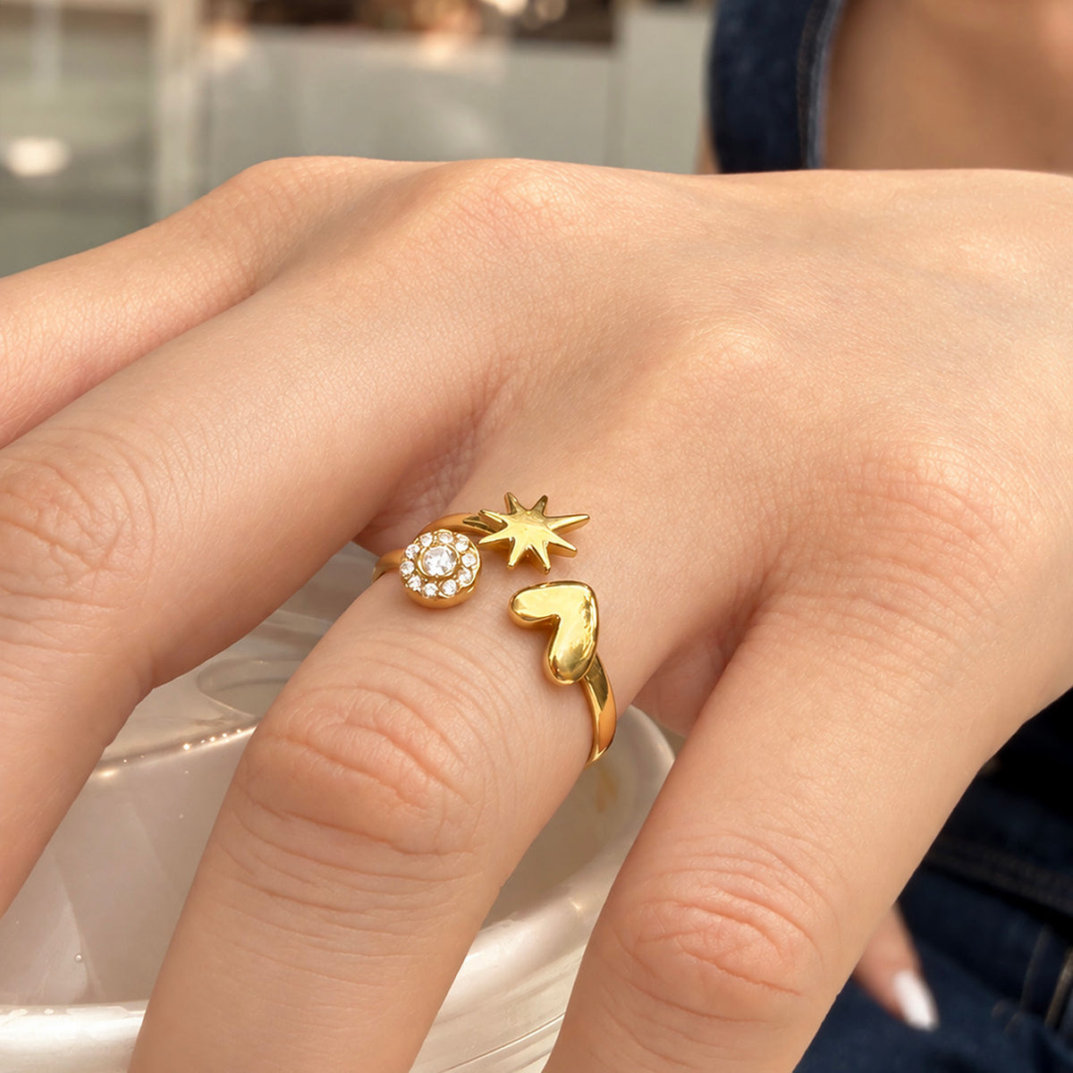 A479 gold-tone stainless steel open ring worn on a finger, showing a heart, star and round stone accent