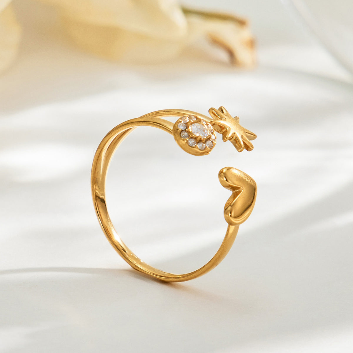 Side view of the A479 gold-tone heart and star open ring with a round clear-stone accent