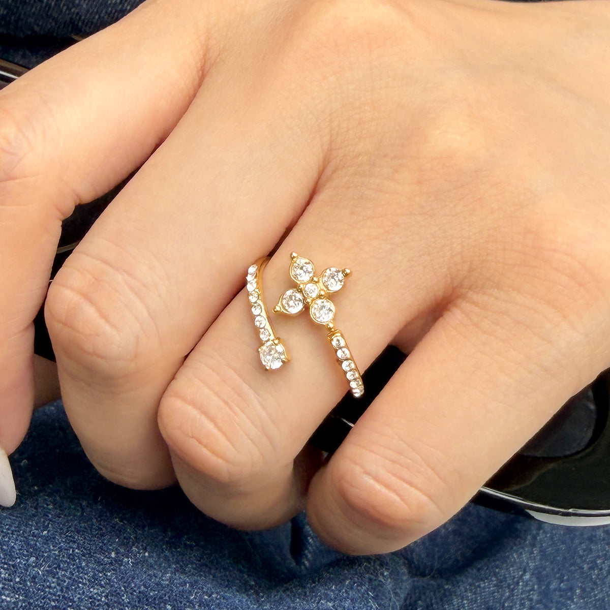 A643 gold-tone open ring with a four-petal clear-stone flower worn on a finger