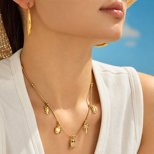 Stainless steel charm necklace worn with multiple animal and tropical pendant details