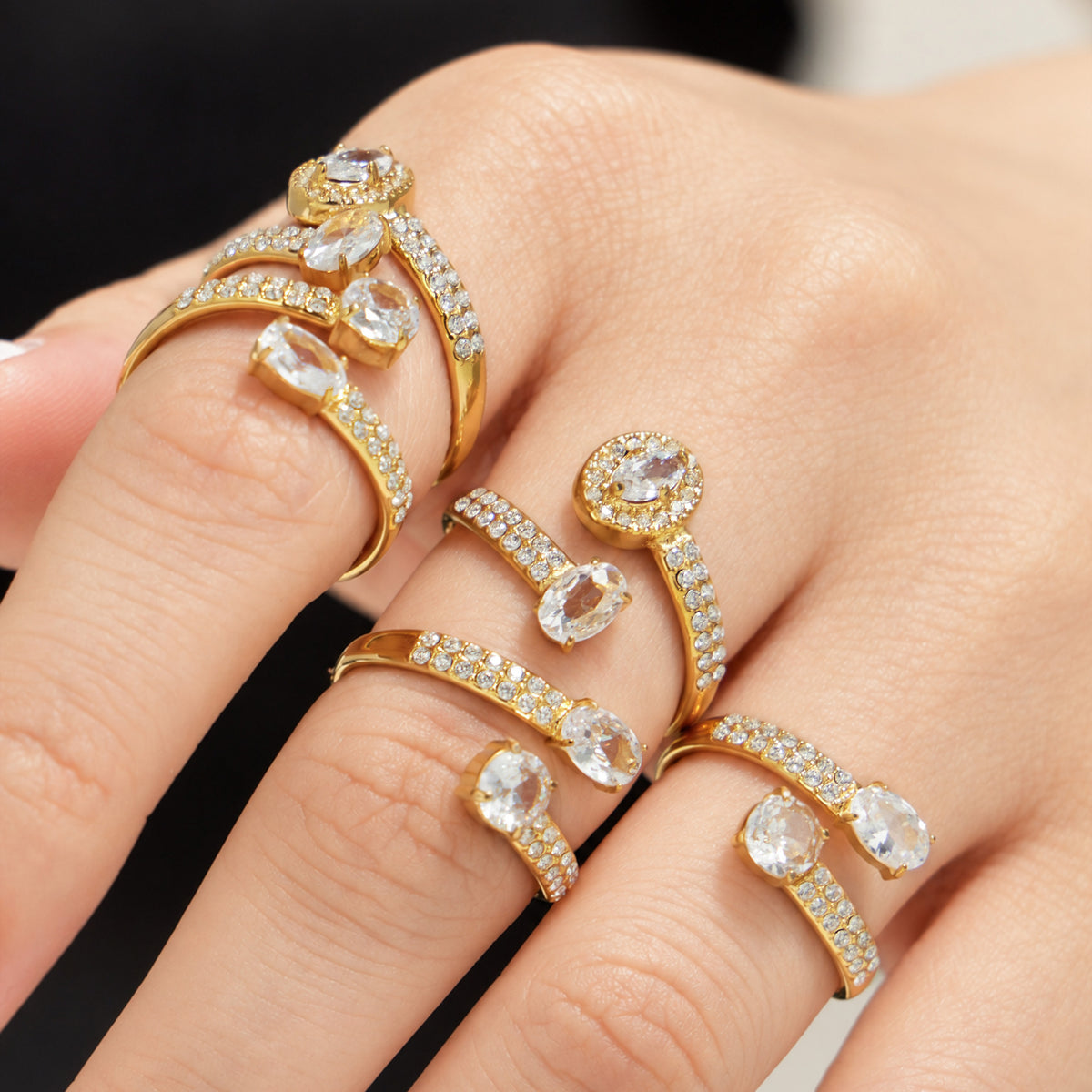 Stainless steel cubic zirconia open rings in gold-tone styles worn together on hand