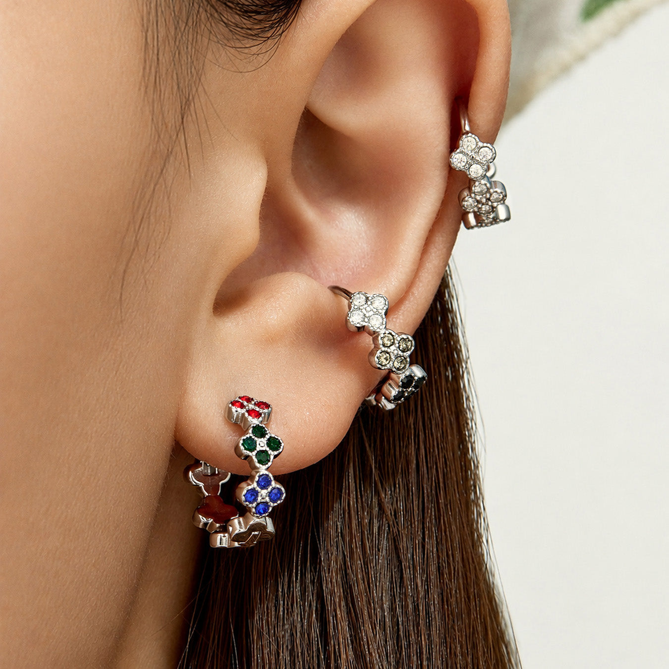 Model wearing steel multicolor cubic zirconia four-leaf clover huggie earrings