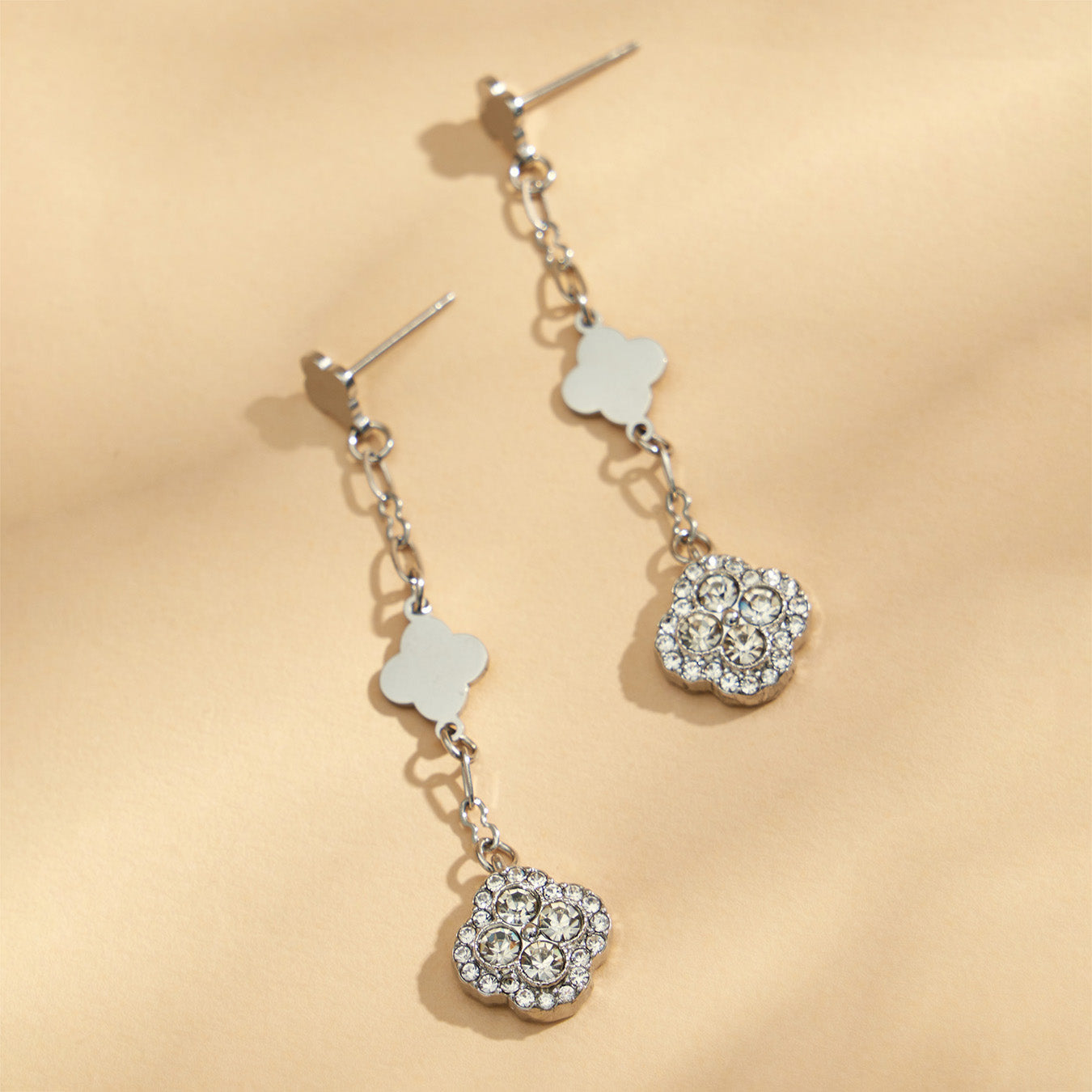 Steel-tone four leaf clover drop earrings with white crystal pavé details